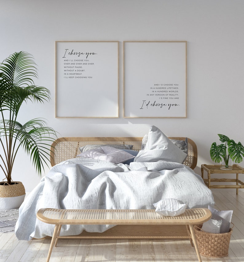 Pu&ograve; includere: Due stampe artistiche incorniciate con testo nero su sfondo bianco. La stampa a sinistra riporta I choose you, quella a destra And I'd choose you. Le stampe sono esposte sopra un letto con struttura in legno chiaro e testiera in paglia di Vienna.