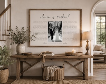 May include: A rectangular wall art print in a wooden frame featuring the names Olivia and Michael in black script, a central black and white wedding photograph, and two columns of text with the date November 10, 2023, printed at the bottom.