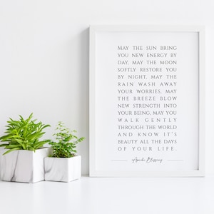 May include: A white framed print with a motivational quote about finding strength and beauty in everyday life. The quote reads, "May the sun bring you new energy by day, may the moon softly restore you by night. May the rain wash away your worries. May the breeze blow new strength into your being, may you walk gently through the world and know it's beauty all the days of your life." The quote is signed "Apache Blessing".