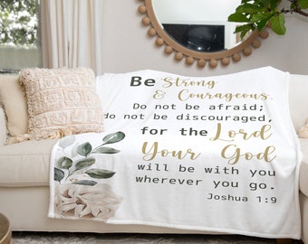 May include: White throw blanket with a floral design and a gold inspirational quote: "Be Strong & Courageous. Do not be afraid; do not be discouraged, for the Lord Your God will be with you wherever you go. Joshua 1:9"