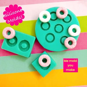 May include: Teal silicone moulds in various shapes, including circles and squares, with Life Savers candies. The image includes text that reads "Silicone Molds!" and "Me mold you make."