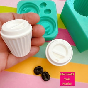 May include: White miniature coffee cup and lid, with a ridged design, next to a matching lid and two coffee bean-shaped objects. Two teal silicone molds are also visible. The text "Me mold you make" is on a pink square.