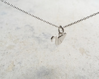 May include: A silver-colored metal necklace featuring a small, three-dimensional origami crane pendant. The pendant is suspended from a delicate, thin silver-toned chain with small, uniform circular links that connect to a jump ring holding the crane.