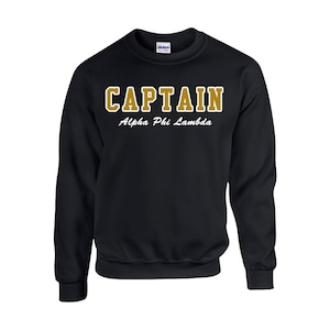 May include: Black sweatshirt with gold lettering that reads "CAPTAIN Alpha Phi Lambda".