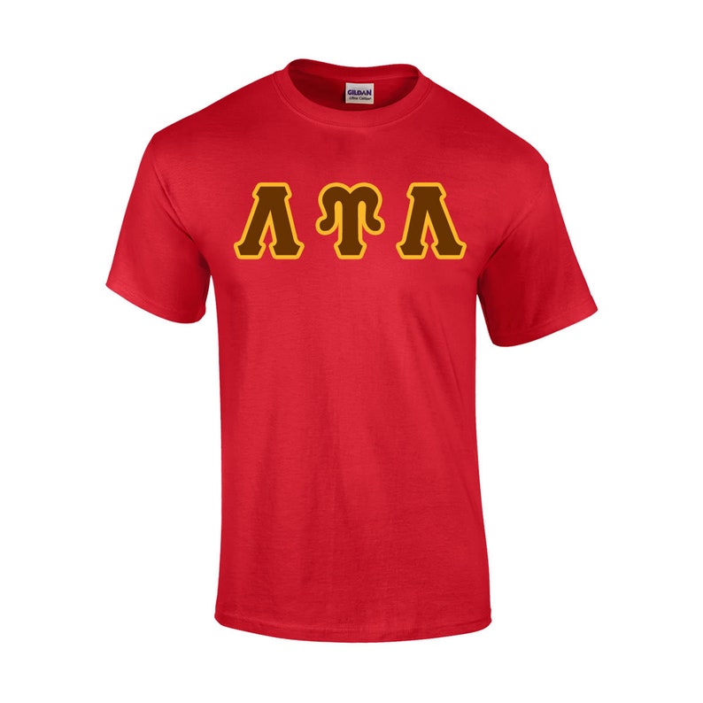May include: A red t-shirt with the letters "ATA" in a brown and yellow design across the chest. The shirt is made of a soft material and has short sleeves. The Gildan logo is visible on the collar.