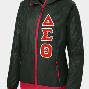 May include: Black windbreaker jacket with red accents and a white Greek letter design on the front. The letters are Delta, Sigma, and Theta.