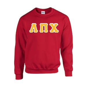 May include: A red crewneck sweatshirt with the Greek letters ΛΠX in yellow with a white outline. The sweatshirt is made of a soft material and has a classic, casual style. The Gildan logo is visible on the collar.