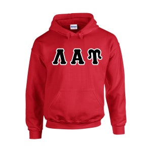 May include: A red hooded sweatshirt with the letters AAT in black with a white outline across the chest. The sweatshirt has a front pocket and a drawstring hood. The brand name "Gildan" is visible on the tag.