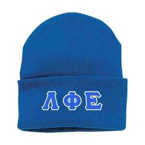 May include: Royal blue knit beanie with a fold-over cuff and a white outline of the Greek letters Lambda Phi Epsilon in blue.