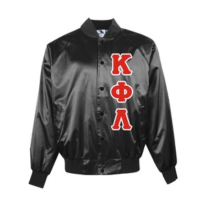 May include: Black satin jacket with red and white Greek letters KΦΛ. The jacket has a button-up front, black ribbed cuffs, and a black ribbed hem. The jacket is a classic varsity style.