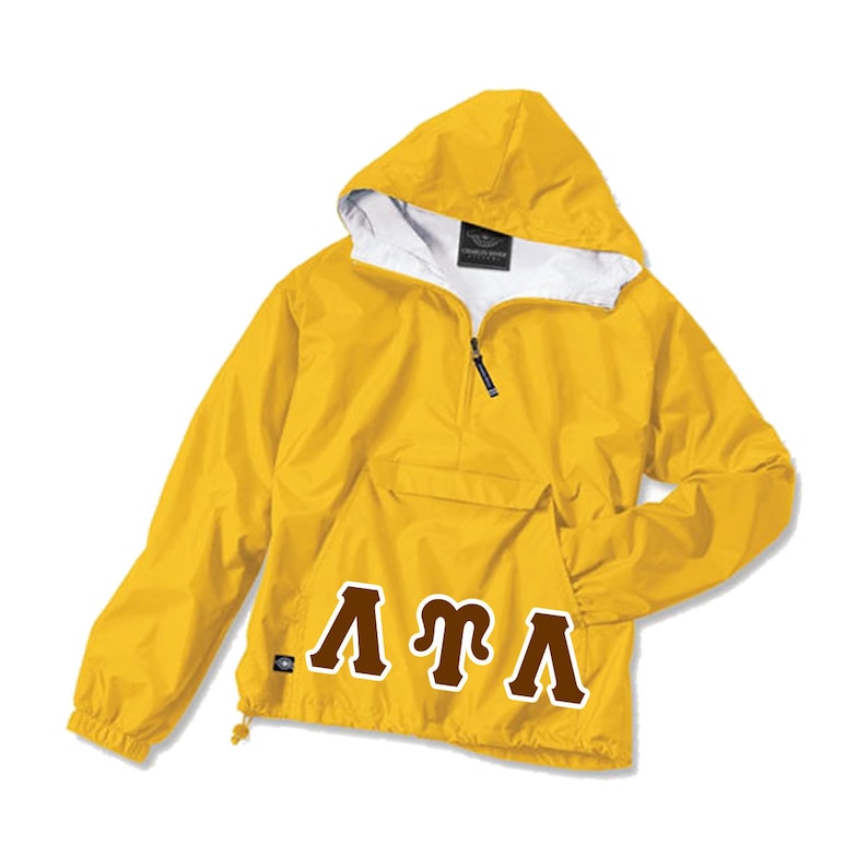 May include: A yellow hooded anorak jacket with a white interior lining. The jacket features a half-zip closure, a front pocket, and the Greek letters "&Lambda;&Tau;&Lambda;" in brown. The jacket is designed for outdoor wear.