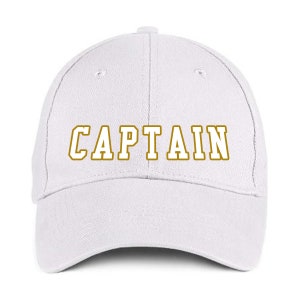 May include: White baseball cap with the word "CAPTAIN" in gold lettering across the front. The hat has a curved brim and a button on top. A classic, casual accessory.