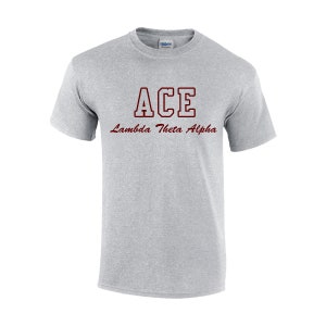 May include: A light gray t-shirt with the word "ACE" in maroon block letters and "Lambda Theta Alpha" in maroon script. The shirt is a crew neck style and appears to be made of cotton.
