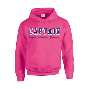 May include: A pink hooded sweatshirt with the text "CAPTAIN Sigma Lambda Gamma" in navy blue and white lettering.