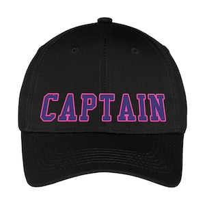 May include: Black baseball cap with the word "CAPTAIN" in pink letters with a purple outline. The cap has a curved brim and a button on top. This hat is a great accessory for any casual outfit.