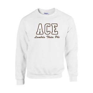 May include: White crewneck sweatshirt with the word "ACE" in brown block letters with a brown outline. Below the word "ACE" is the text "Lambda Theta Phi" in brown script. The sweatshirt is made of a soft material.