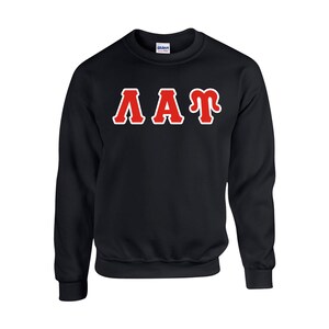 Peut inclure: Sweat-shirt noir avec les lettres "AAT" en rouge bord&eacute;es de blanc sur la poitrine. Le sweat-shirt est en mati&egrave;re douce et poss&egrave;de un col, des poignets et un ourlet c&ocirc;tel&eacute;s. Le logo Gildan est visible sur l'&eacute;tiquette.