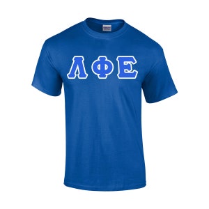 May include: Royal blue t-shirt with the Greek letters ΛΦΕ in white-outlined blue. The short-sleeved shirt is made of a soft material and features a crew neck. The letters are centered on the front of the shirt.