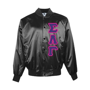 May include: Black satin bomber jacket with a button-up front and ribbed cuffs and hem. The jacket features the Greek letters ΣΑΓ in purple with a pink outline on the front. A classic varsity style.