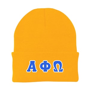 May include: A yellow knit beanie with a blue embroidered AΦΩ logo.