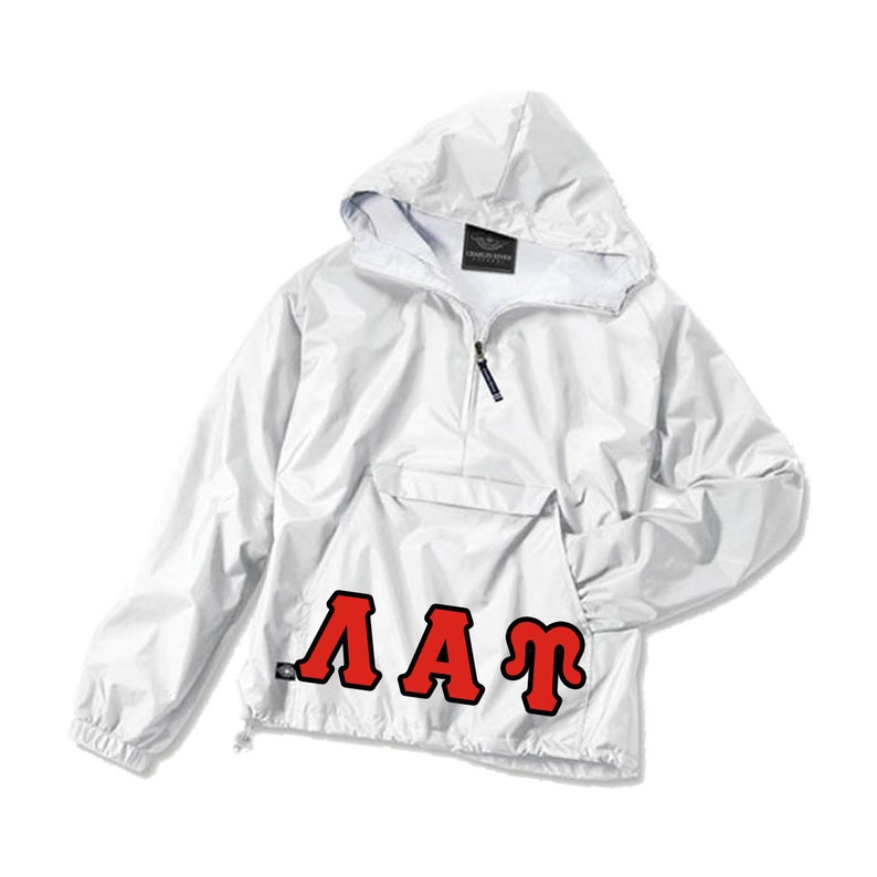 Puede incluir: Chaqueta anorak blanca con capucha, bolsillo delantero y cierre de media cremallera. La chaqueta presenta las letras rojas "AAT" en la parte delantera. La chaqueta tiene un cord&oacute;n en el dobladillo inferior.