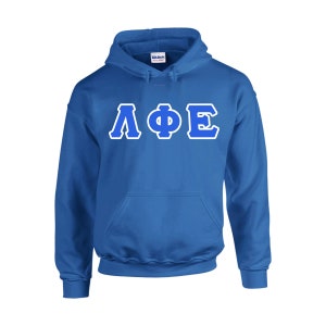 May include: A royal blue hooded sweatshirt with a front pocket and white-outlined Greek letters. The letters are in a bold, sans-serif font. The brand name "Gildan" is visible on the tag.