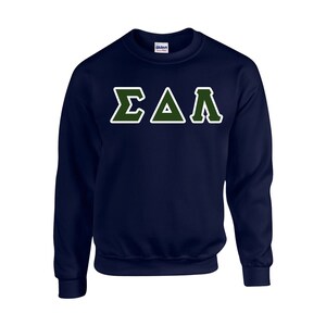 May include: Navy blue sweatshirt with the Greek letters ΣΔΛ in green with a white outline. The sweatshirt is a crew neck style and features the Gildan logo on the upper back.