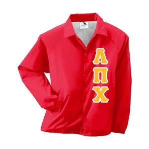 May include: A bright red nylon jacket with a button-up front, collar, and side pockets. The jacket features the Greek letters ΛΠX in a gold color with a white outline on the front. The jacket is a lightweight outerwear garment.