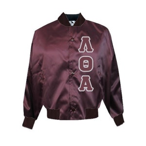 May include: A maroon satin bomber jacket with the letters "AOA" in white and gray. The jacket has a button-up front, a black collar, and matching cuffs and waistband. This jacket is a classic style.