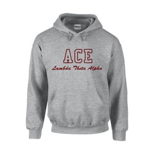 May include: A gray hooded sweatshirt with a front pocket and drawstring. The word "ACE" is printed in a maroon, block-style font above the words "Lambda Theta Alpha" in a cursive font.