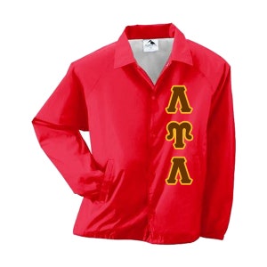 May include: A red nylon coach jacket with a button-up front, collar, and side pockets. The jacket features the Greek letters Lambda, Mu, and Lambda in brown with a gold outline on the front.