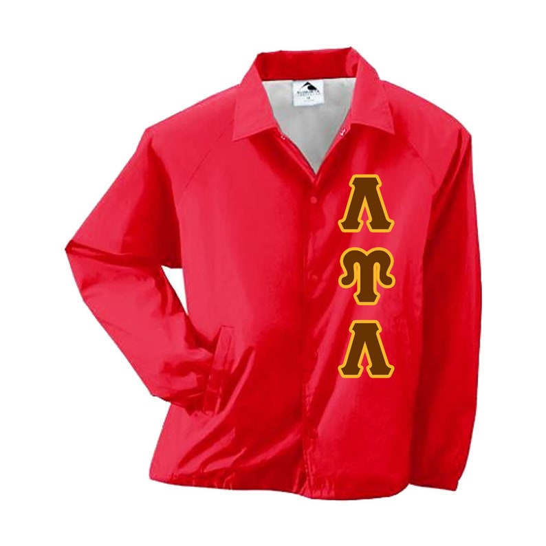 May include: A red nylon coach jacket with a button-up front, collar, and side pockets. The jacket features the Greek letters Lambda, Mu, and Lambda in brown with a gold outline on the front.
