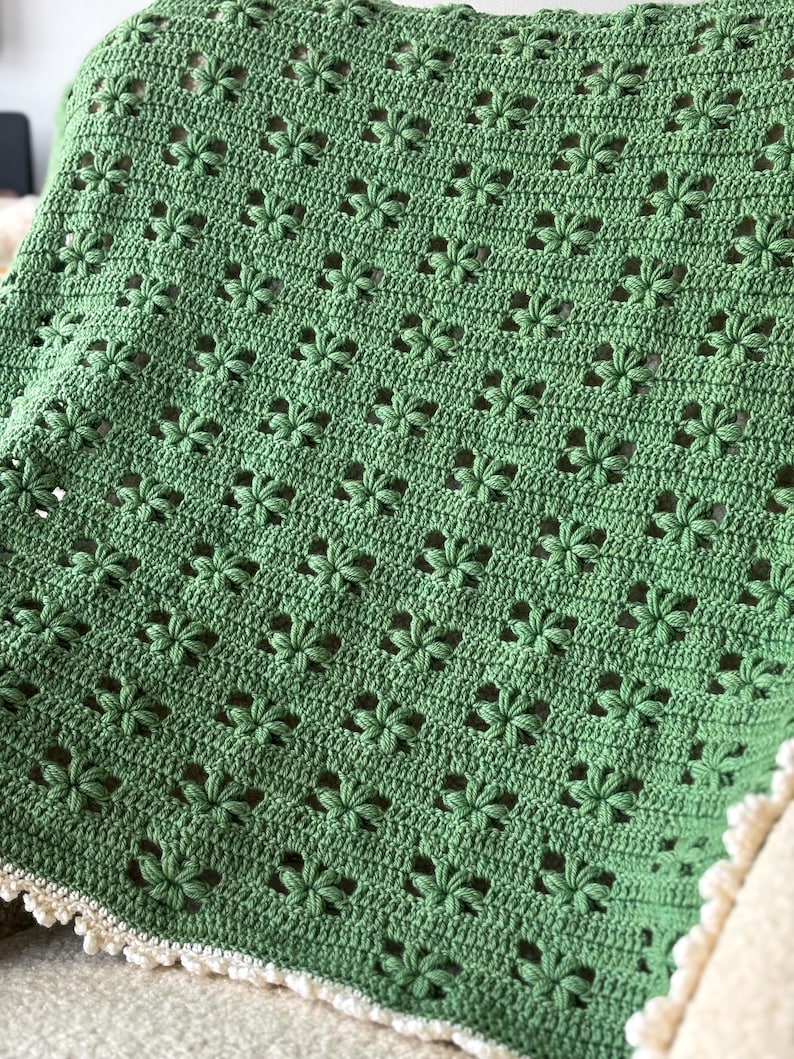 crochet flower blanket spread out on a sofa