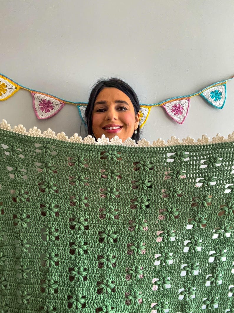 a young woman holding a flower blanket in green