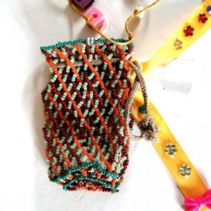 Petit sac avec des petites perles, un ruban jaune et des sequins. Pour rangement bijoux