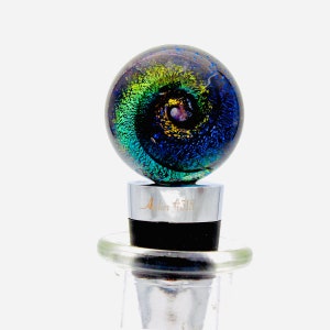 May include: A glass bottle stopper with a swirling blue, green, and gold design. The stopper is labeled "Atelier #315".