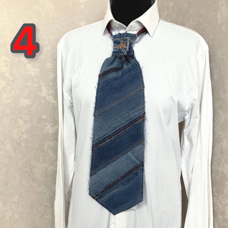 May include: A necktie crafted from strips of blue denim fabric with frayed edges, featuring a central metal button at the knot. The tie is worn over a crisp white long-sleeved button-down shirt. The number 4 is displayed in red in the upper left.