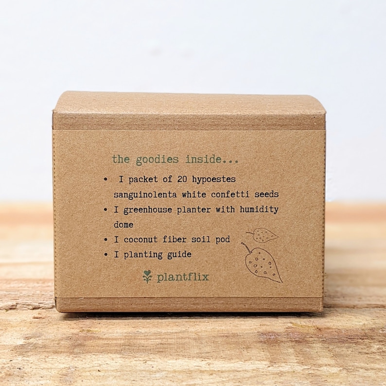 May include: A brown cardboard box with the text "the goodies inside..." listing contents: seeds, a greenhouse planter, a soil pod, and a planting guide. The brand name "plantflix" is at the bottom.
