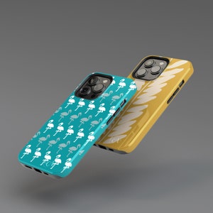 May include: Two phone cases. One is teal with a pattern of white and gray flamingos. The other is gold with a white leaf design. Both cases have black camera surrounds and black sides.