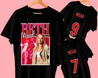 May include: Black t-shirt with a red and white graphic of Beth Mead, a soccer player, with the text "Beth Mead" in a retro font. The shirt also has a red number 9 on the back.