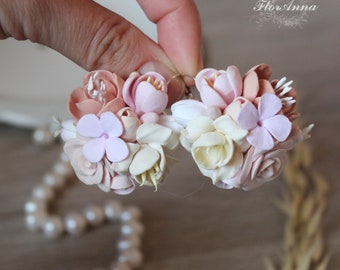May include: A pair of floral earrings with pink, white, and peach colored flowers. The earrings are made of polymer clay and are handmade.