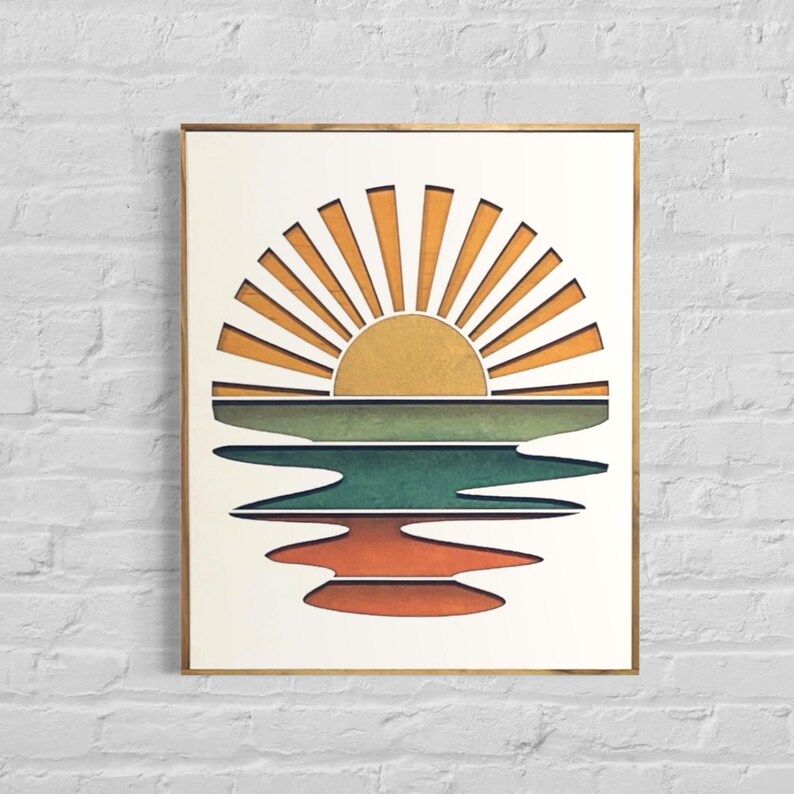 May include: A framed print of a stylized sunset over a body of water. The sun is depicted as a yellow circle with orange rays, and the water is represented by three horizontal bands of green, blue, and orange.