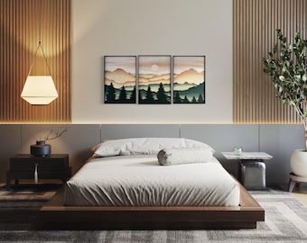 May include: A bedroom with a wooden platform bed, a gray headboard, and a set of three framed landscape prints above the bed. The prints feature a mountain scene with a sunset sky and a silhouette of trees. The room has a wooden floor and a rug with a geometric pattern.