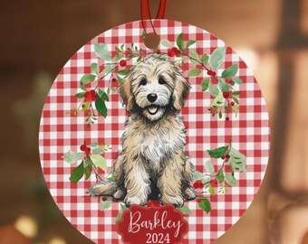 May include: A round, red and white gingham patterned Christmas bauble featuring a doodle dog with a wreath of greenery and red berries. The bauble is personalised with the name "Barkley" and the year "2024".
