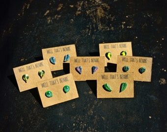 May include: Eight pairs of small, colorful leaf-shaped earrings on brown cards with the text "Well That's Bizarre" printed on each card.
