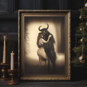 May include: A framed sepia-toned artwork depicts a horned, dark figure embracing a nude person with long red hair. The artwork is in a gold ornate frame, with a Christmas tree and candles in the background.