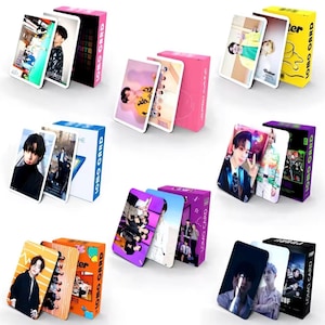 May include: Several sets of LOMO cards featuring images of a musical group. Each set includes multiple cards and a matching box. The boxes are various colors, including pink, yellow, purple, and orange. The cards display colorful photos of the group.