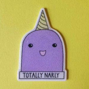May include: Purple narwhal with a yellow and white spiral horn and a white banner with the text "TOTALLY NARLY" on a yellow background.