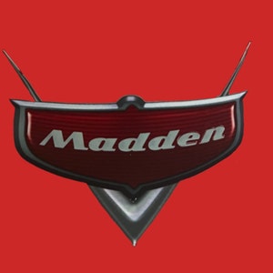 May include: A red and silver car emblem with the word "Madden" in white lettering.