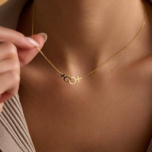 May include: A gold chain necklace with a pendant featuring a circle with a cross on either side.